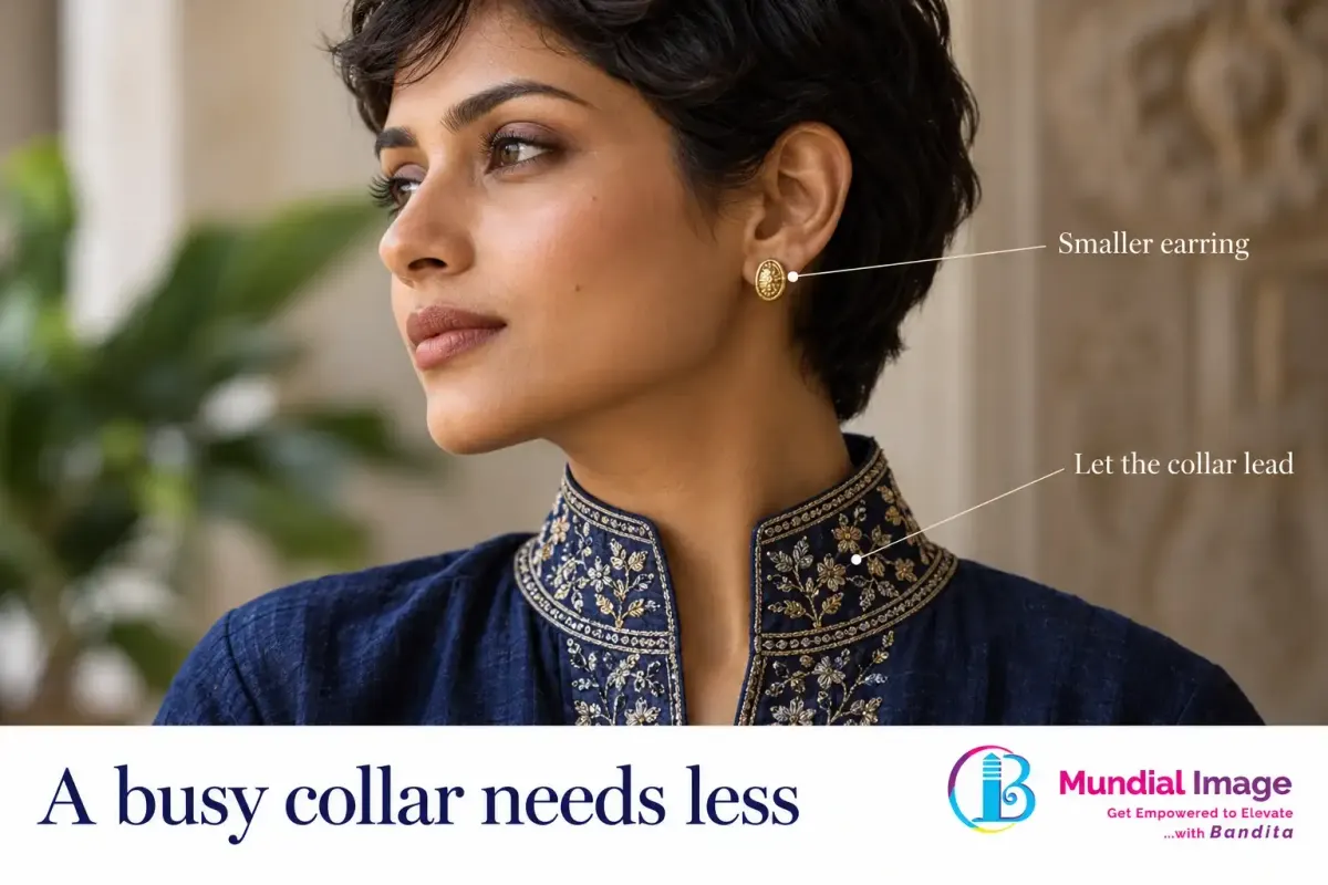 Compact gold earring beside an embroidered high indigo collar.