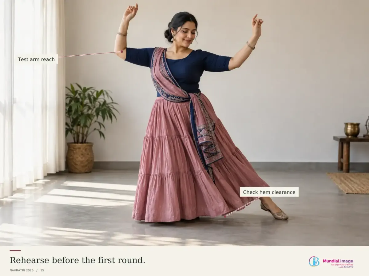 Indian woman rehearsing a side step with arms raised in her complete Garba outfit.