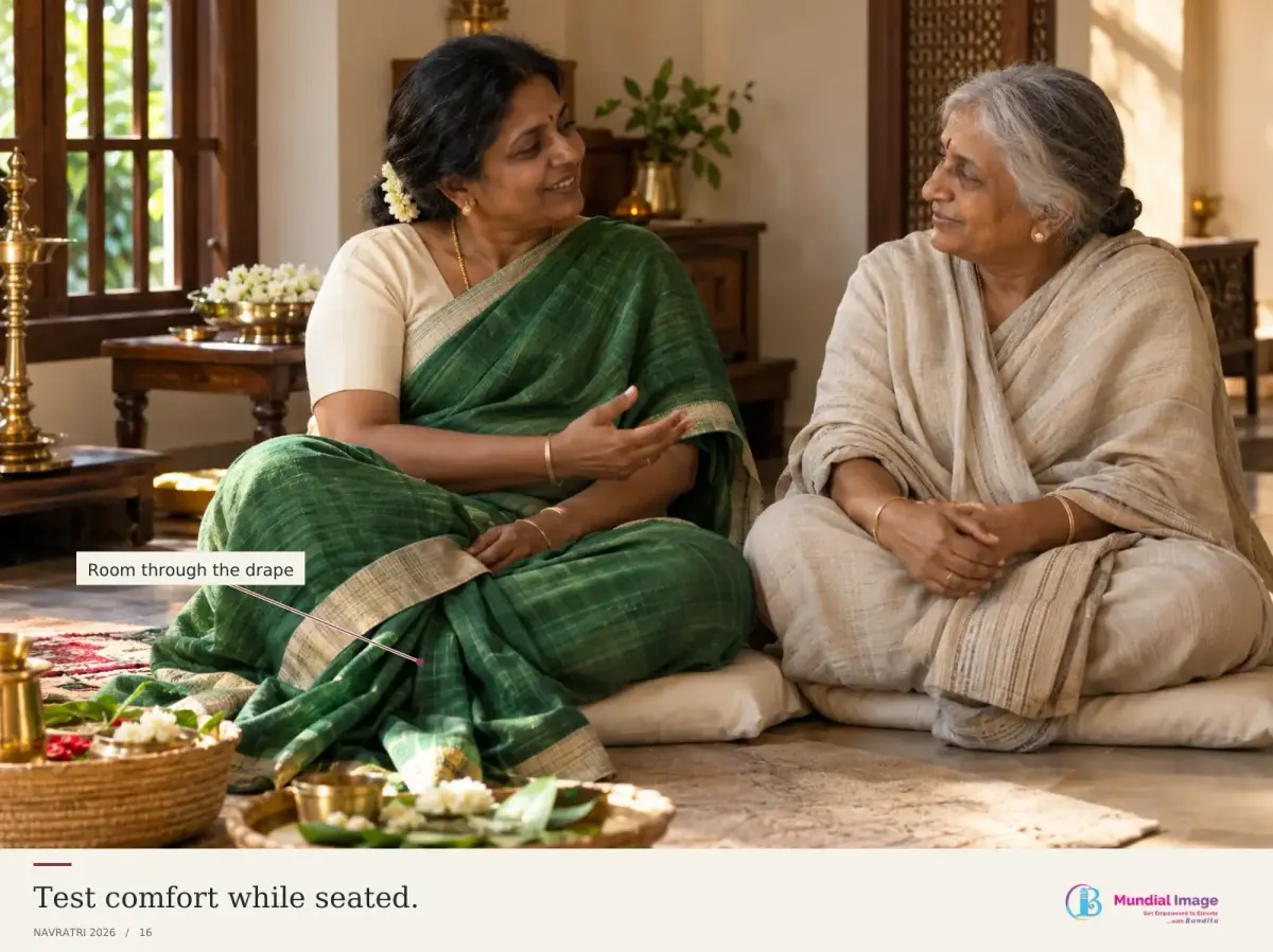 Indian woman seated comfortably in a green saree in a quiet family-puja setting.