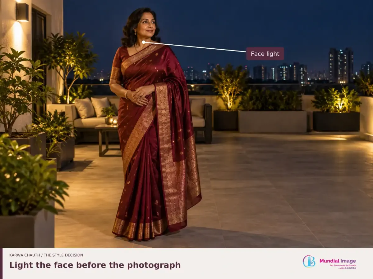 Woman in a wine saree on a residential terrace at night, with the illuminated face highlighted.