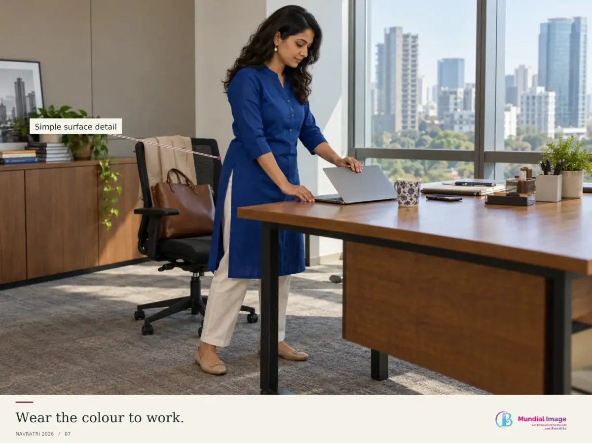 Indian professional in a royal-blue kurta and trousers at an office desk.